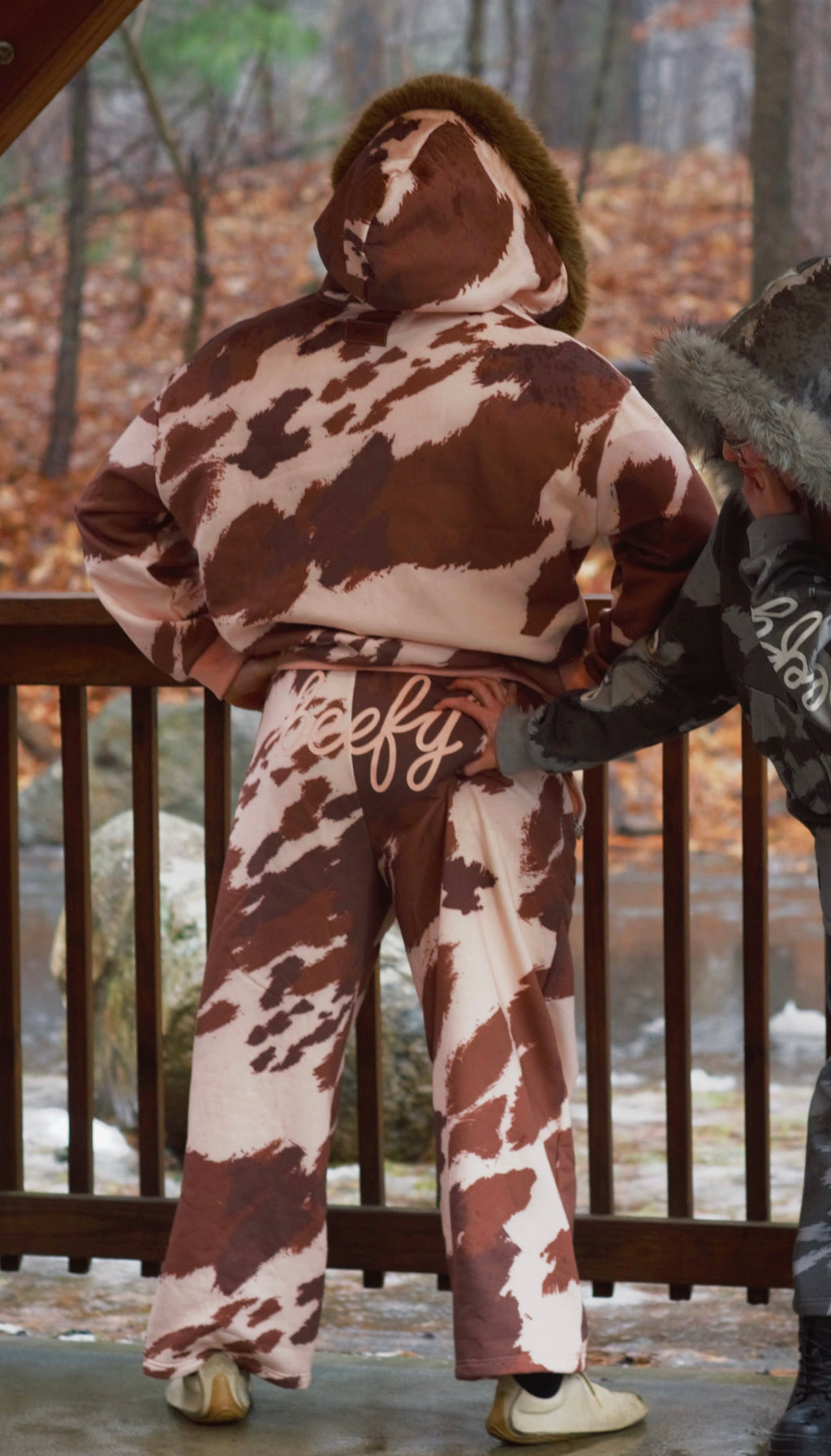 Two people wearing cow-print sweatsets